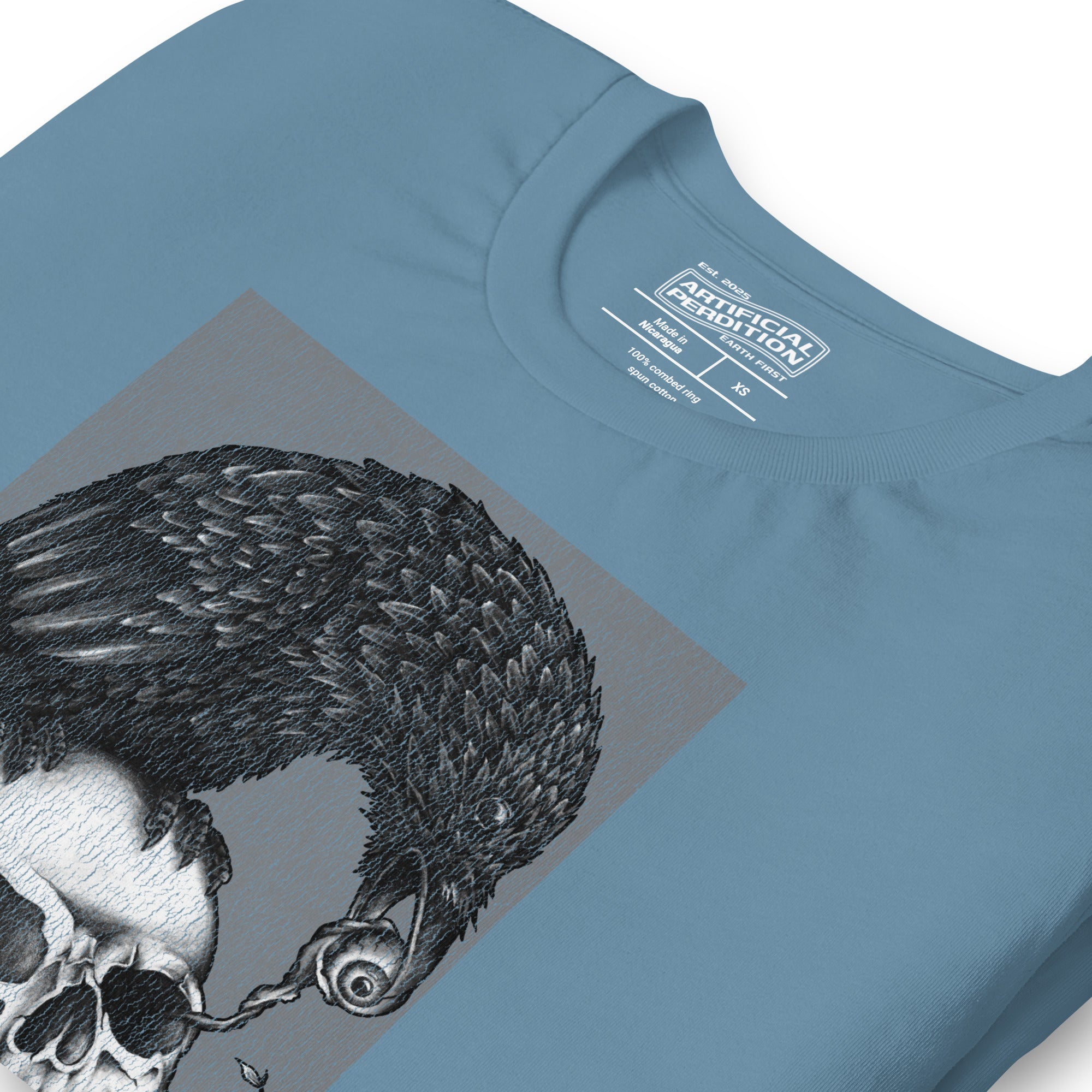 Graphite illustration of a black corvid perched on a human skull removing the eye, sprouting branch beside it, Last Look, Artificial Perdition apparel