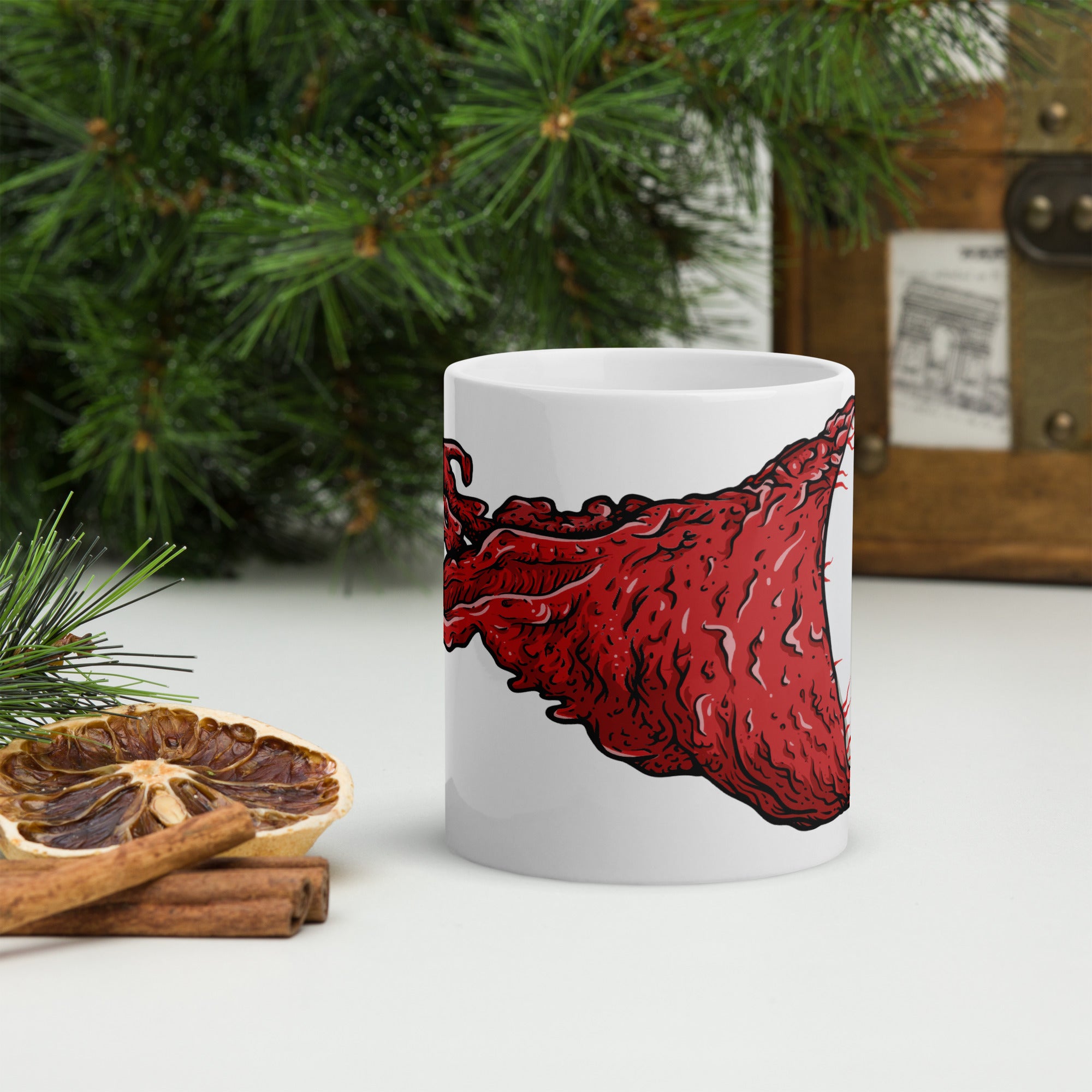 White glossy ceramic mug featuring a wrap-around illustration of a blue eye with exposed red flesh trailing behind it.