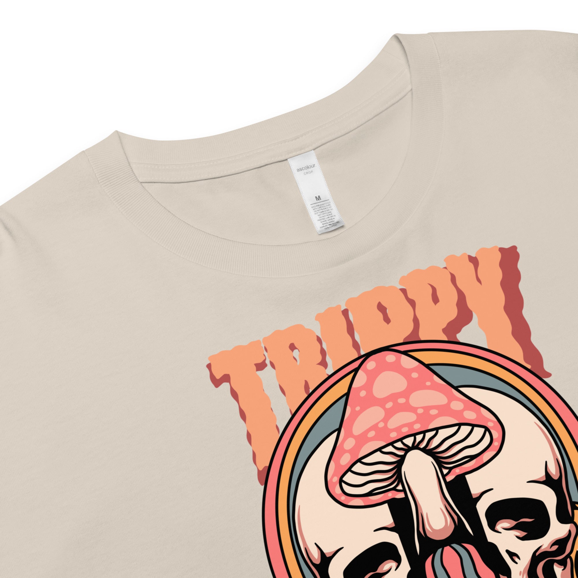 Cropped tee featuring a split skull and mushroom design with melting psychedelic color and smiley faces. Soft combed cotton, eco-friendly inks, playful surreal vibe.