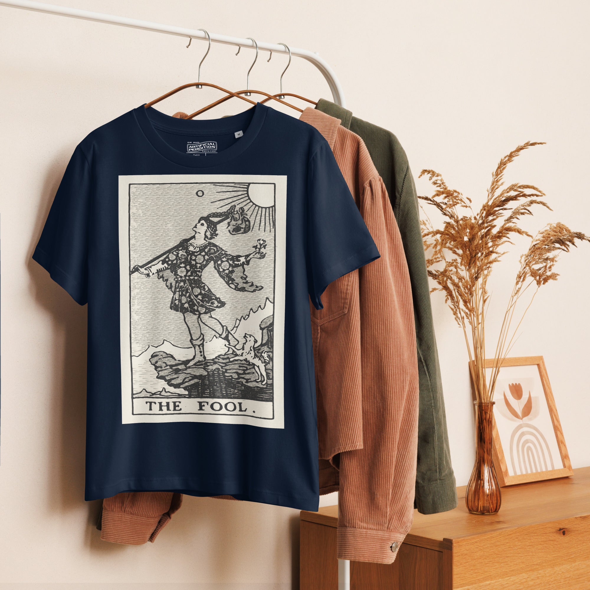Fitted organic cotton t-shirt featuring The Fool tarot card illustration in high-contrast woodcut rendering.
