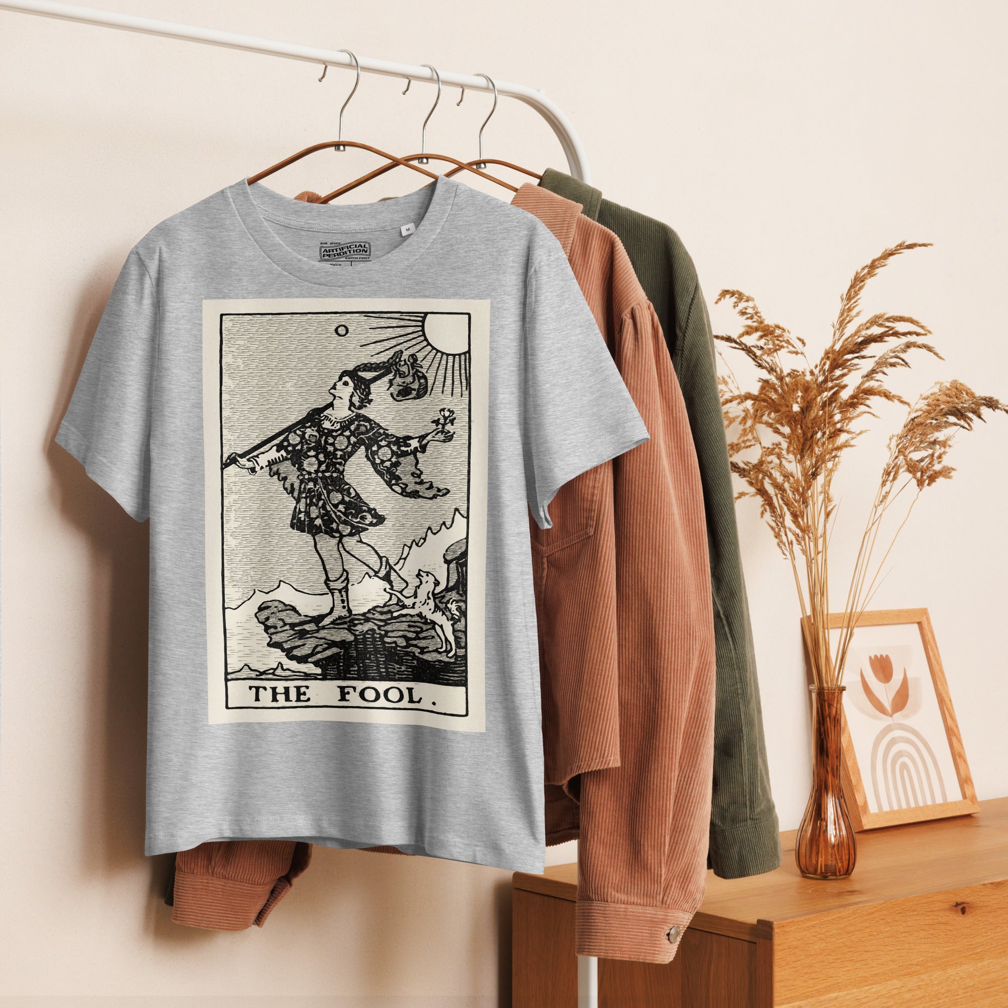 Fitted organic cotton t-shirt featuring The Fool tarot card illustration in high-contrast woodcut rendering.